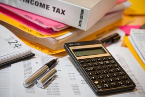 Calculator, pen and files for paying taxes